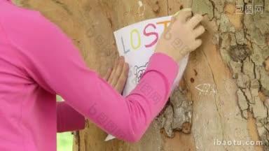 小孩在<strong>树干</strong>上张贴失踪宠物的海报